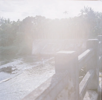 一个人坐在河边的一张木凳上