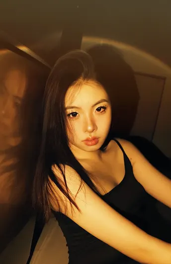 一个穿着黑色连衣裙的女人在一个光线昏暗的房间里