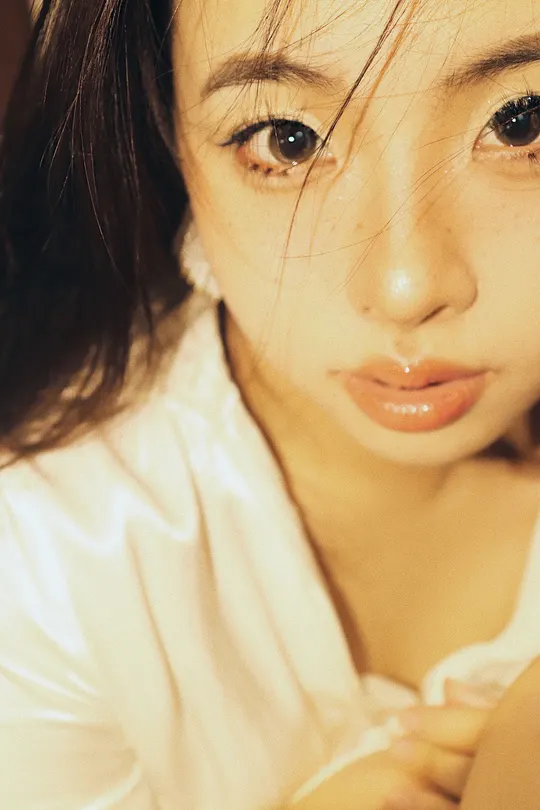 一位穿着白衬衫的年轻女子 她的头发挡住了眼睛。