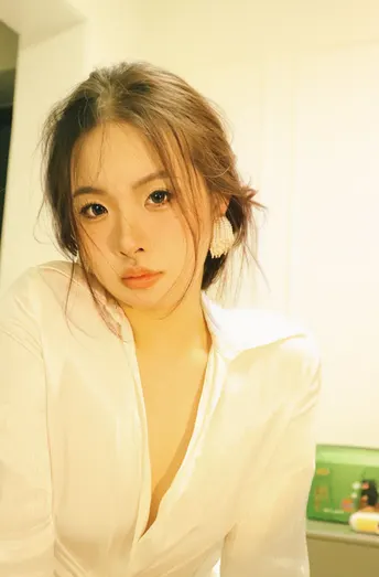 一位年轻女子穿着白色衬衫站在浴室里自拍