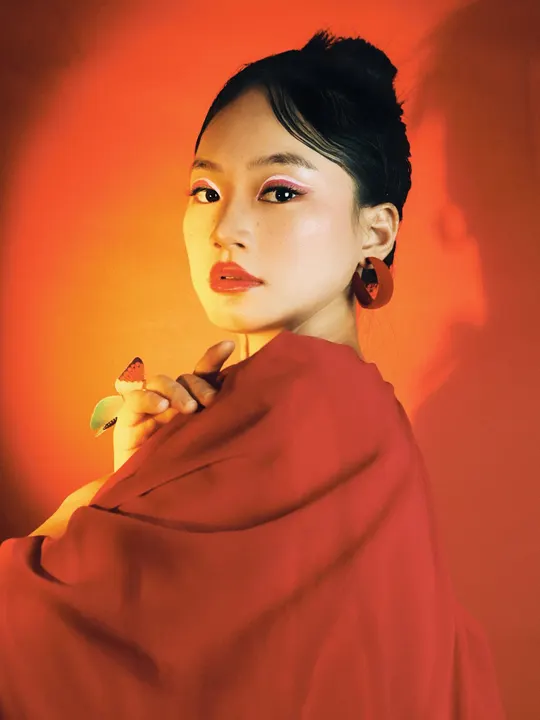 一位穿着红色衣服的女子手里拿着某物