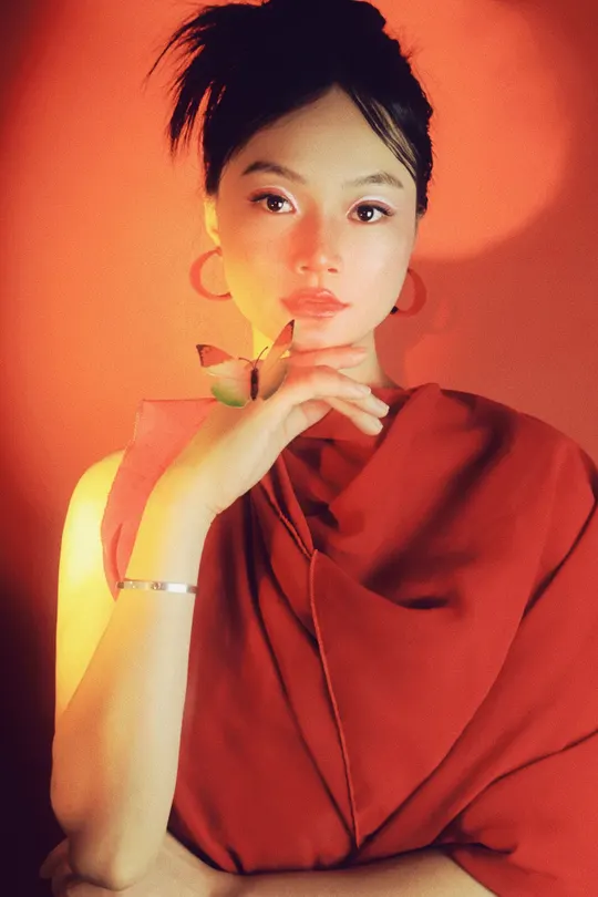 一位穿着红裙子的女人在黄光下