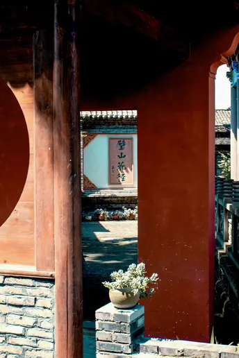 一个带红门的庭院 有柱子和花。