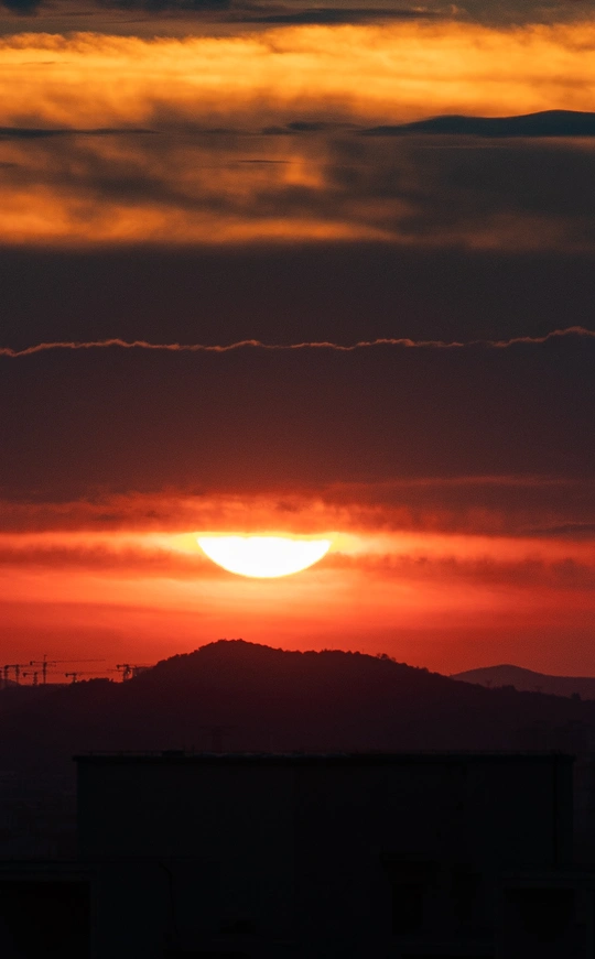 落日 太阳在山的背后落下 地平线上有云。