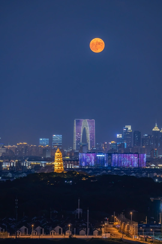 夜晚 城市天际线上满月升起。