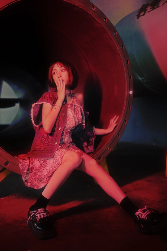 一个年轻女子穿着一条裙子坐在一个大物体内部。