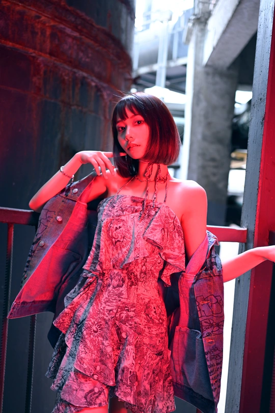 一个年轻女子穿着红色连衣裙站在户外。