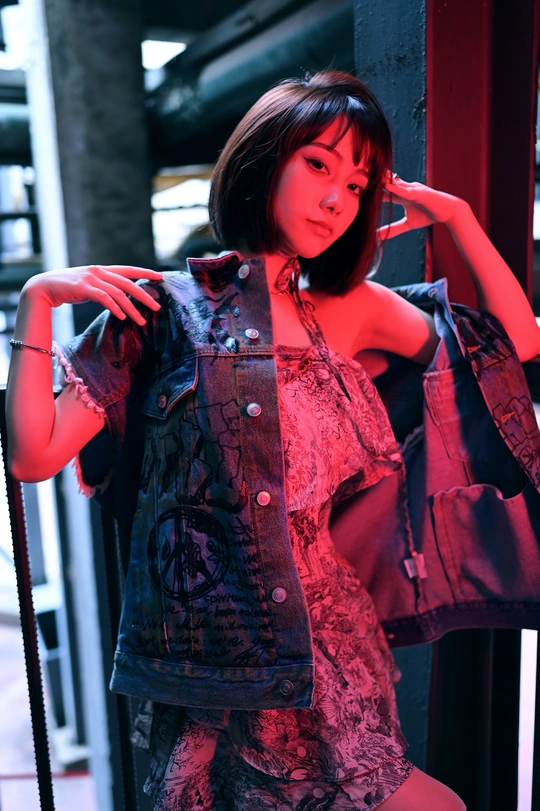 一个年轻女子穿着 overalls 手拿钱包和香烟。