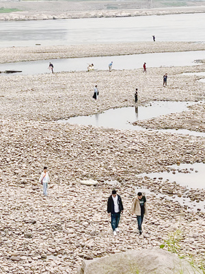 人们在退潮时在岩石海滩上行走