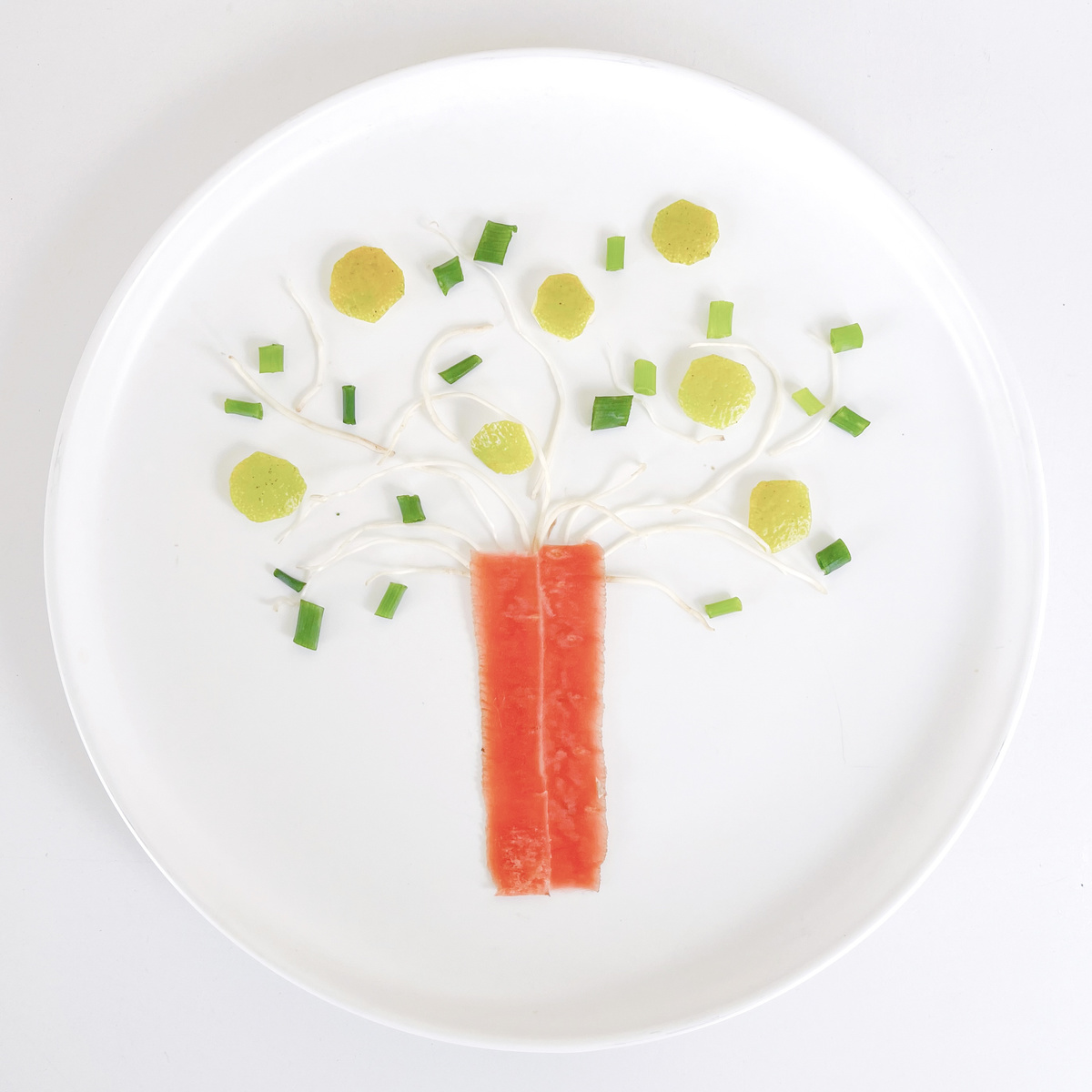 一块带有食物的树形图案的白盘子