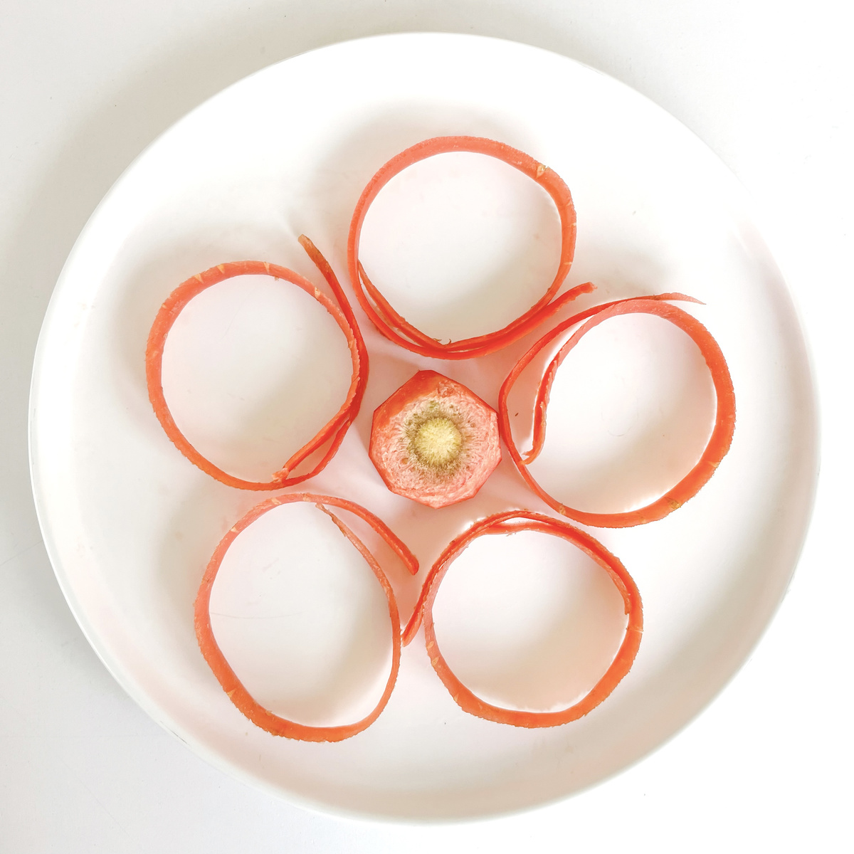 鸡蛋和胡萝卜切片覆盖的白盘